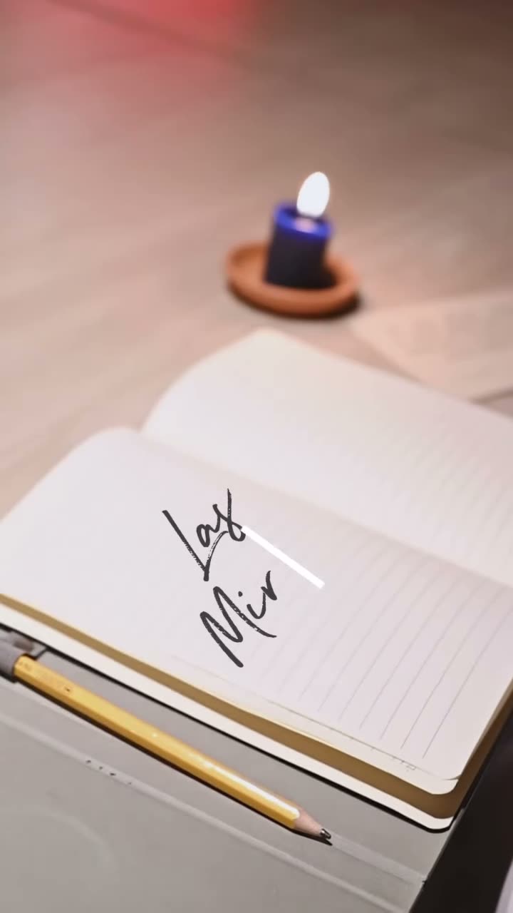 Cuaderno abierto con la palabra Mironas escrita a mano junto a una vela